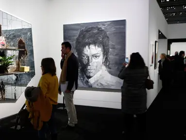 Pengunjung melihat lukisan seniman AS Rashid Johnson "The Whiz" (2012) dan "In Memory of Michael Jackson" (2017) karya seniman China Yan Pei-Ming dalam pameran Michael Jackson: On The Wall di museum Grand Palais, Paris, Rabu (21/11). (AP/Francois Mori)