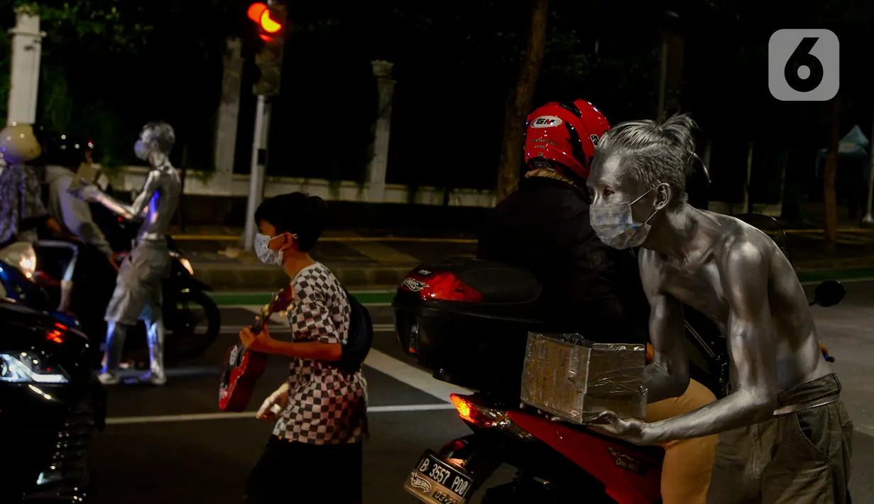 Manusia silver saat menghibur pengendara bermotor di perempatan kawasan Senayan, Jakarta, Sabtu (9/5/2020). Meskipun di tengah pandemi Covid-19, para manusia silver ini masih tetap melakukan aksinya di jalanan untuk memenuhi kebutuhan sehari-hari. (merdeka.com/Imam Buhori)