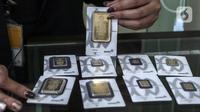 Pramuniaga menunjukkan emas batangan PT Aneka Tambang (Antam) Tbk di sebuah gerai emas, Jakarta, Senin (18/1/2021). Pada hari ini, harga emas Antam turun menjadi Rp 944 ribu per gram. (Liputan6.com/Johan Tallo)