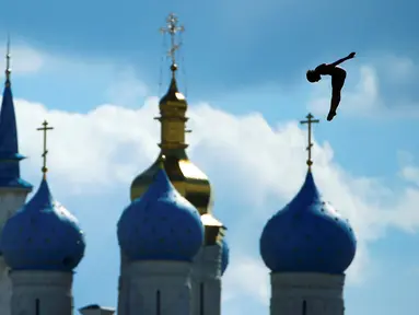 Peloncat indah Inggris, Gary Hunt, beraksi di nomor High Diving 27m putra dalam Kejuaraan Dunia Akuatik 2015 di Kazan, Rusia. (3/8/2015). Bangunan di latar gambar adalah Masjid Kul Sharif (kiri) dan Katedral Annunciation. (Reuters/Hannibal Hanschke).