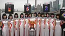 Gadis Grid atau Grid Girls berpose di belakang piala pemenang untuk Grand Prix Formula 1 China di Sanghai (26/3/2013). Grid Girls akan dihapus saat seri pertama F1 di Melbourne, Australia Maret 2018. (AFP FOTO / Tam Peterja)