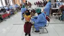 Petugas kesehatan menyuntikkan vaksin COVID-19 kepada siswa di SDN 02 Ciater, Tangerang Selatan, Selasa (14/12/2021). Mulai Hari ini, 11 provinsi di Indonesia secara serentak melaksanakan vaksinasi COVID-19 dengan sasaran anak berusia 6 hingga 11 tahun. (merdeka.com/Arie Basuki)