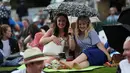 Dua fans wanita menggunakan payung untuk berlindung dari hujan pada hari pertama Kejuaraan Tenis Wimbledon 2017 di The All England Lawn Tennis Club di Wimbledon, London barat daya, Inggris (3/7). (AFP Photo/Daniel Leal-Olivas)