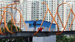 Pekerja menyelesaikan pembangunan jembatan penyeberangan orang (skywalk) di kawasan Kebayoran Lama, Jakarta, Rabu (2/11/2022). Pengerjaan skywalk sepanjang 500 meter dengan desain cahaya artistik dan dilengkapi fasilitas lift nantinya mengintegrasikan Stasiun Kebayoran dengan Halte Transjakarta Koridor 8 dan Koridor 13. (Liputan6.com/Herman Zakharia)