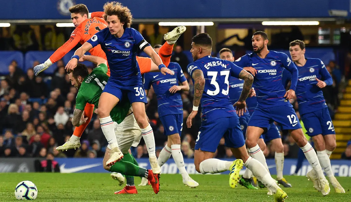 Pemain Chelsea, Kepa Arrizabalaga dan David Luiz berusaha menghalau bola pada laga lanjutan Premier League yang berlangsung di Stadion Stamford Bridge, London, Kamis (4/4). Chelsea menang 3-0 atas Brighton Albion. (AFP/Glyn Kirk)