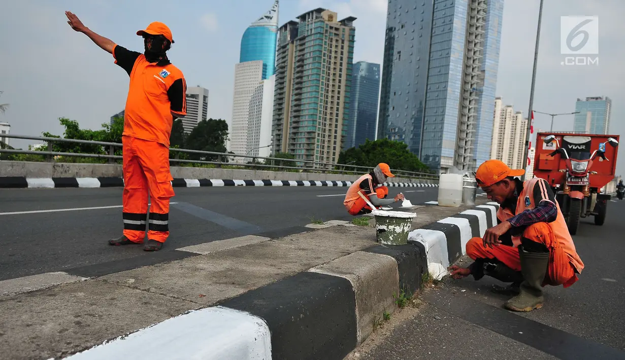 Petugas PSSU mengatur lalu lintas saat rekannya sedang mengecat  kembali  trotoar di Kawasan Jakarta, Selasa (1/8). Pengecatan dilakukan dalam rangka mempercantik wilayah yang disinergikan dengan menyambut HUT RI ke-72. (Liputan6.com/Helmi Afandi)