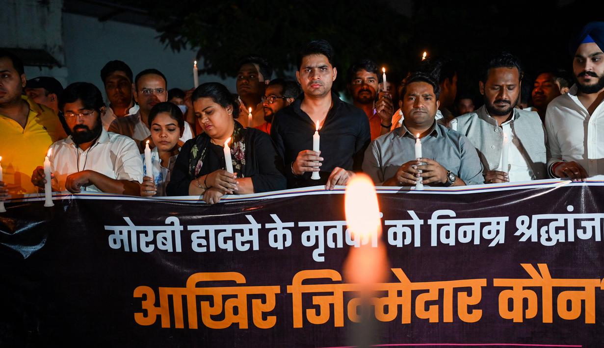 <p>Anggota Kongres Pemuda India ikut serta dalam pawai menyalakan lilin di New Delhi, India, Senin (31/10/2022). Lilin dinyalakan sebagai bentuk penghormatan kepada para korban yang meninggal setelah tragedi jembatan ambruk di seberang Sungai Machchhu. (AFP/Sajjad HUSSAIN)</p>