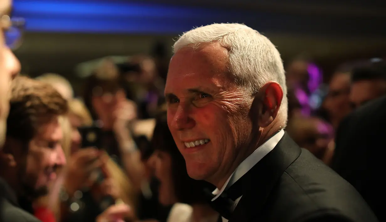 Mike Pence tersenyum saat mengunjungi Indiana Society Ball, Washington, DC. AS (19/1). Dunia akan menyaksikan pelantikan Donald Trump dan Mike Pence sebagai Presiden dan Wakil Presiden AS. (Spencer Platt/Getty Images/AFP)