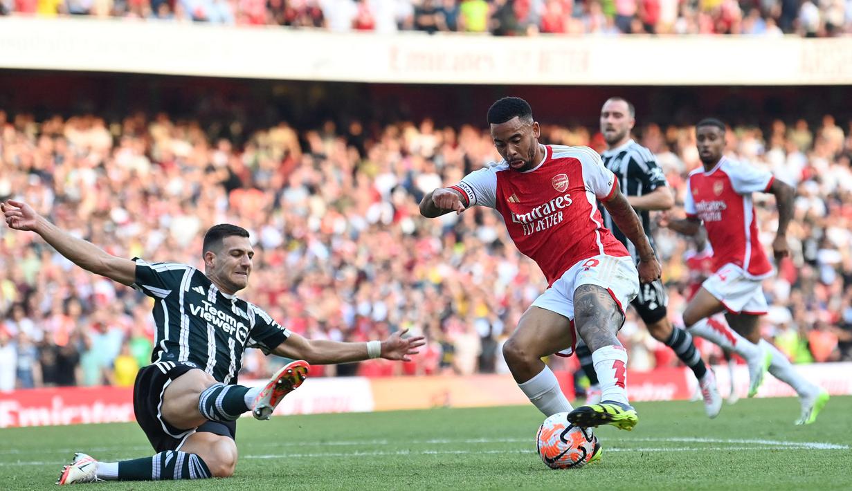 Arsenal menjadi tim pertama yang sukses memenangkan laga berkat dua gol penentu pada masa injury time di Liga Inggris musim 2023/2024. Momen itu terjadi pada pekan ke-4 saat The Gunners menang 3-1 atas Manchester United di Emirates Stadium (3/9/2023). Hingga penghujung waktu normal skor masih imbang 1-1. Pada masa injury time The Gunners sukses mencetak dua gol melalui Declan Rice (96') dan Gabriel Jesus (101'). (AFP/Glyn Kirk)