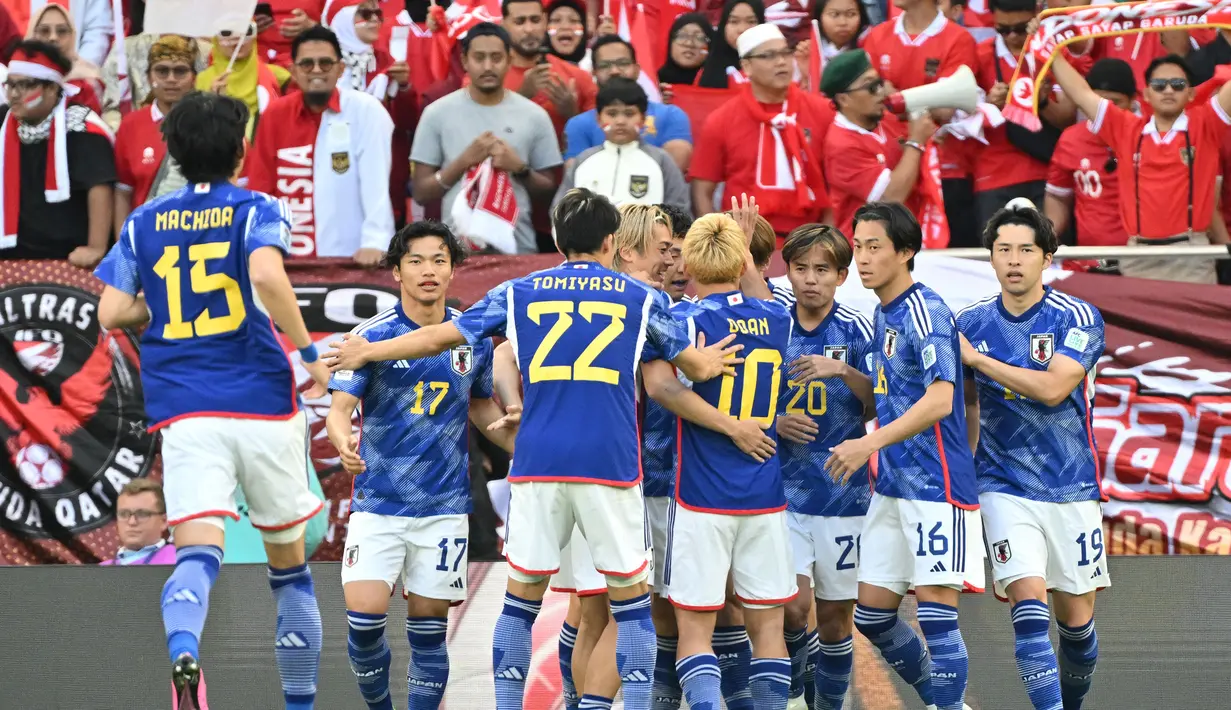 Para pemain Timnas Jepang merayakan gol pertama ke gawang Timnas Indonesia yang dicetak striker Ayase Ueda lewat eksekusi penalti pada laga ketiga Grup D Piala Asia 2024 di Al-Thumama Stadium, Doha, Qatar, Rabu (24/1/2024) malam WIB. (AFP/Hector Retamal)