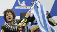 Pebalap Tim Mooney VR46, Marco Bezzecchi merayakan kemenangan dengan jersey Timnas Argentina bertandatangan Lionel Messi saat menjuarai MotoGP Argentina 2023 di Aut&oacute;dromo Termas de R&iacute;o Hondo, Argentina, Senin (03/04/2023) dini hari WIB. Selebrasi tersebut diketahui meniru sang gurunya, Valentino Rossi yang dilakukan pada musim 2015 silam. (AFP/Juan Mabromata)