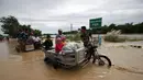 Warga naik ojek untuk menyeberangi banjir setelah hujan lebat di Kota Candaba, Pampanga, Manila, Filipina (17/12). Sembilan orang tewas akibat bencana yang terjadi di Filipina. (REUTERS/Romeo Ranoco)