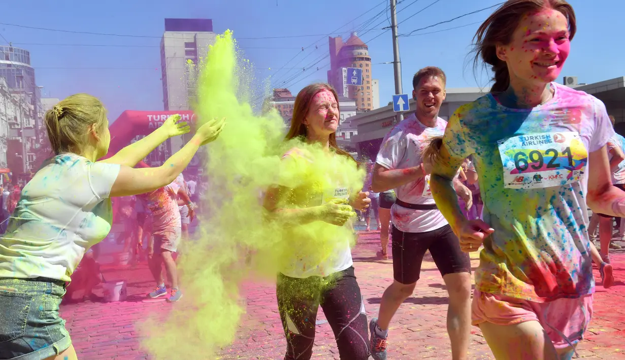 Para pelari melewati semburan bubuk warna-warni saat mengikuti Kyiv Color Run di Kiev, Ukraina, Minggu (10/6). The Color Run diluncurkan dan diselenggarakan pertama kali pada Januari 2012 di Amerika Serikat. (AFP PHOTO/Sergei SUPINSKY)