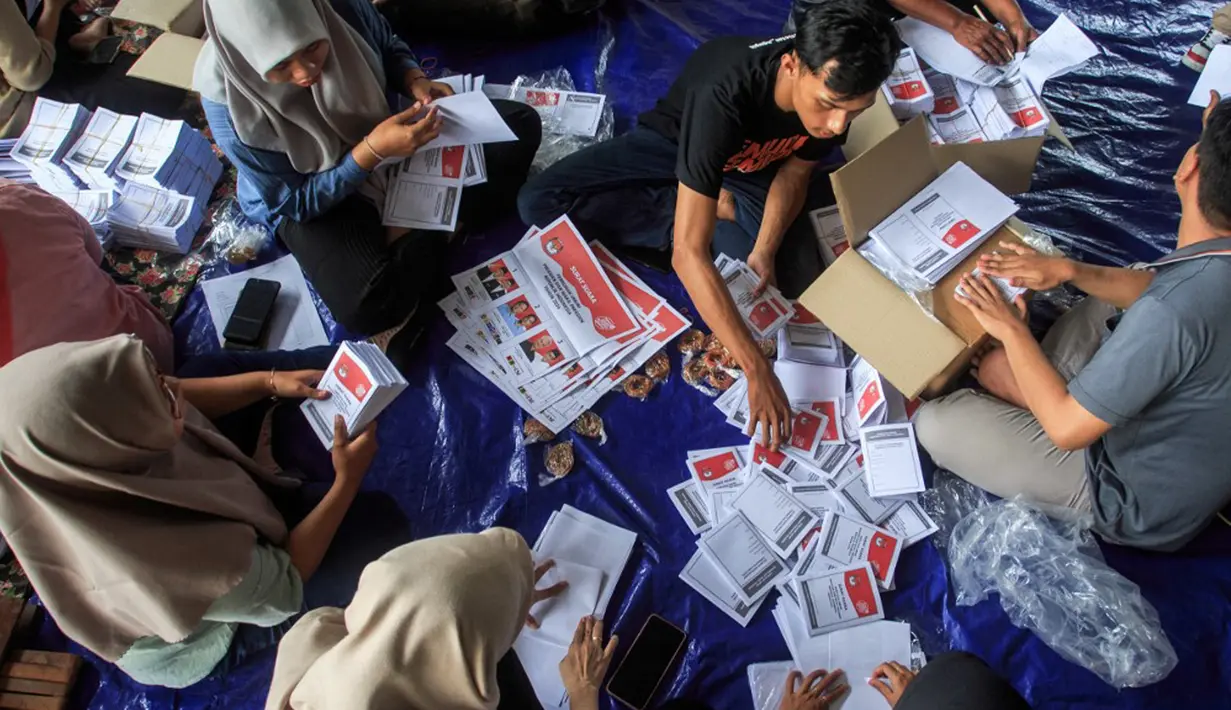 Pekerja melipat surat suara pemilihan presiden yang dijadwalkan pada 14 Februari di Gudang Komisi Pemilihan Umum (KPU) Yogyakarta, Bantul, Kamis (4/1/2024). (DEVI RAHMAN/AFP)