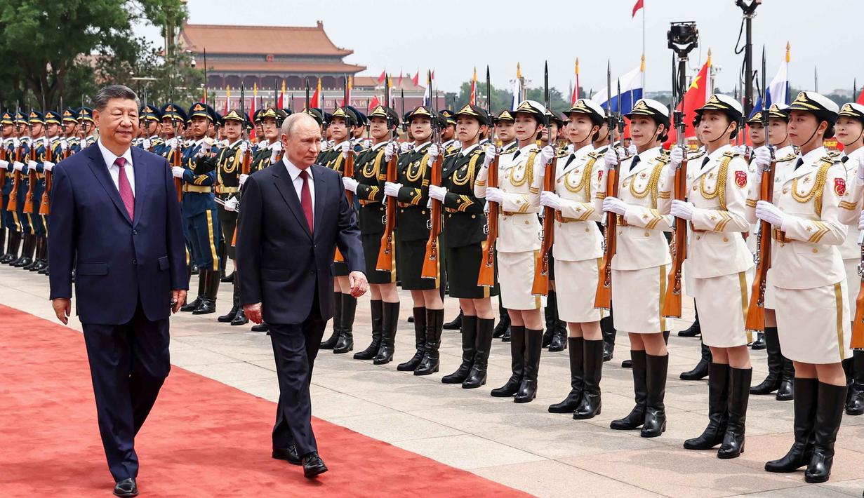 Presiden Rusia Vladimir Putin (kanan) dan Presiden China Xi Jinping memeriksa barisan kehormatan selama upacara penyambutan di Balai Besar Rakyat, Beijing, China, pada Rabu 20 Mei 2026. (Alexander Kazakov, Sputnik, Kremlin Pool Photo via AP)