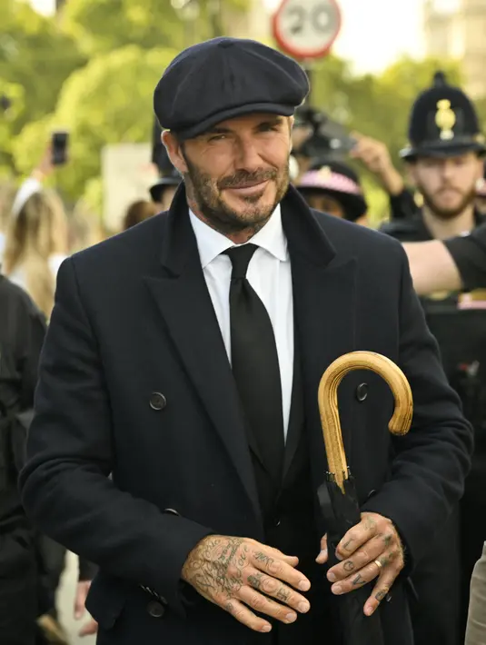 Mantan pemain Timnas Inggris David Beckham meninggalkan Westminster Hall setelah memberikan penghormatan kepada peti mati Ratu Elizabeth II, di Istana Westminster, di London, Jumat (16/9/2022). David Beckham dilaporkan juga berfoto bersama sejumlah dengan penggemar saat mengantre. (Photo by Louisa Gouliamaki / AFP)