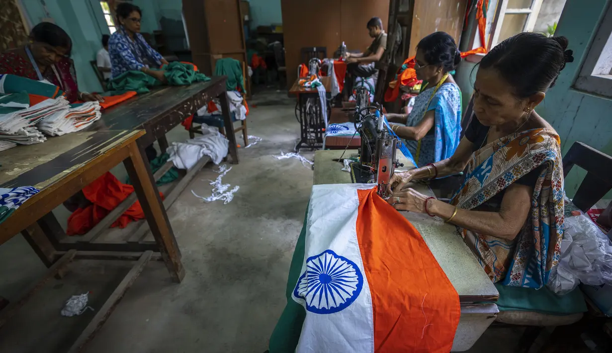 Pegawai pemerintah menjahit bendera tiga warna India di kantor menjelang Hari Kemerdekaan di Gauhati, di negara bagian timur laut Assam, Selasa, 2 Agustus 2022. Perdana Menteri India Narendra Modi telah mengimbau warga untuk mengibarkan atau memajang bendera nasional di Hari Kemerdekaan pada 15 Agustus. (AP Photo/Anupam Nath)