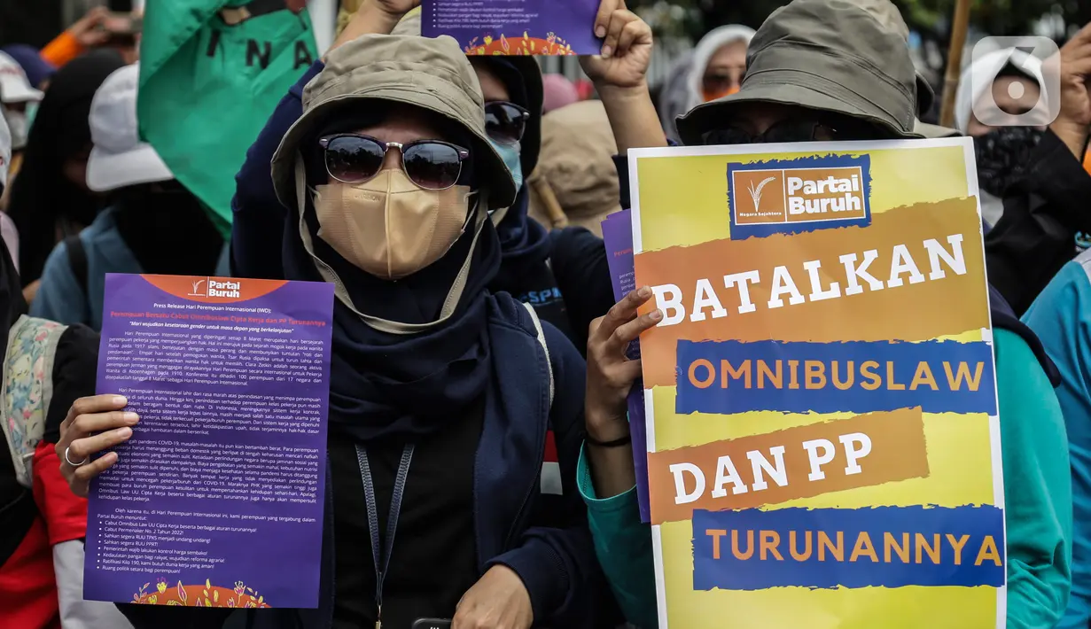 Buruh perempuan memegang poster saat menggelar aksi di depan gedung DPR RI, Jakarta, Selasa (8/3/2022). Buruh perempuan yang tergabung dari beberapa serikat buruh menggelar aksi memperingati Hari Perempuan Internasional atau International Women's Day (IWD) 2022. (Liputan6.com/Johan Tallo)