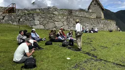 Turis mengunjungi reruntuhan Inca kuno Machu Picchu untuk pertama kalinya setelah ditutup untuk umum, di atas lembah Urubamba, Peru, Rabu (15/2/2023). Pada Januari 2023, lebih dari 300 pelancong di Andes, Peru, sempat terdampar akibat kerusuhan sipil yang membuat pihak berwenang mengevakuasi ratusan orang di Machu Picchu dan menghentikan layanan kereta yang berjalan antara lokasi dan kota Cusco. (Carolina Paucar / AFP)