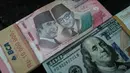 Uang kertas Rp 100.000 diletakkan berdampingan dengan uang dolar Amerika Serikat di salah satu kantor penukaran, Jakarta, Kamis pada 4 Juni 2026. (Yasuyoshi Chiba/AFP)