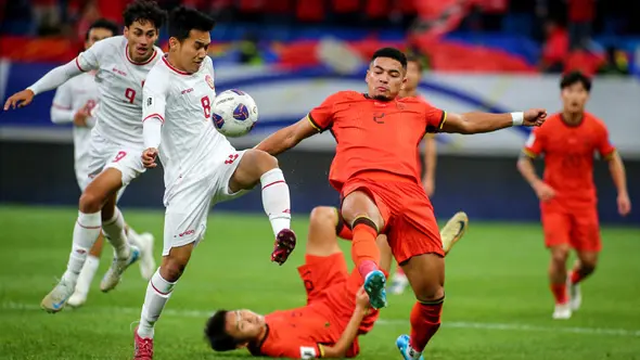 Pemain timnas Indonesia, Witan Sulaeman (kedua kiri) berebut bola dengan Jiang Guangtai (kedua kanan) saat kualifikasi Piala Dunia FIFA 2026 zona Asia melawan China di Qingdao, provinsi Shandong, China timur, pada Selasa 15 Oktober 2024. (Foto oleh AFP/China OUT)