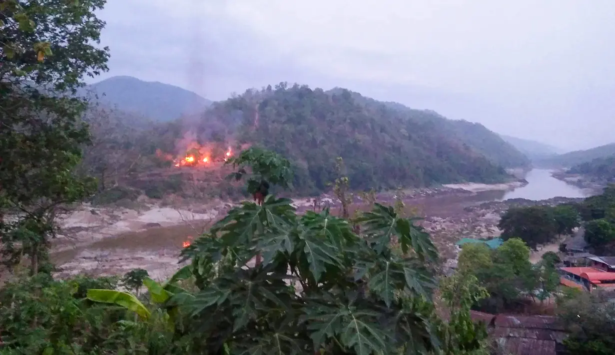 Kebakaran pangkalan militer Myanmar sepanjang tepi Sungai Salween terlihat dari Kota Mae Sam Laep, Provinsi Mae Hong Son, Thailand, Selasa (27/4/2021). Pangkalan militer Myanmar itu diserang dan direbut pemberontak Persatuan Nasional Karen (KNU). (Handout/KAWTHOOLEI TODAY/AFP)