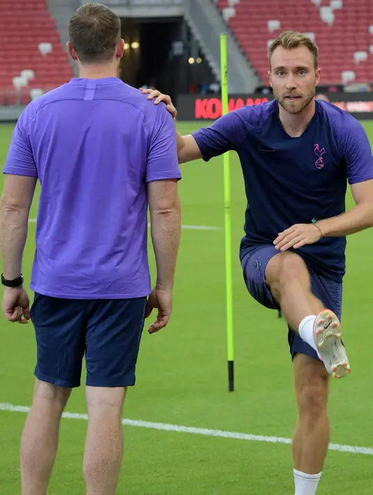 Gelandang Tottenham Hotspur, Christian Eriksen (kanan) melakukan pemanasan selama mengikuti latihan di Singapura  (19/7/2019). Tottenham akan bertanding melawan Juventus pada International Champions Cup 2019 di National Stadium, Singapura. (AFP Photo/Roslan Rahman)