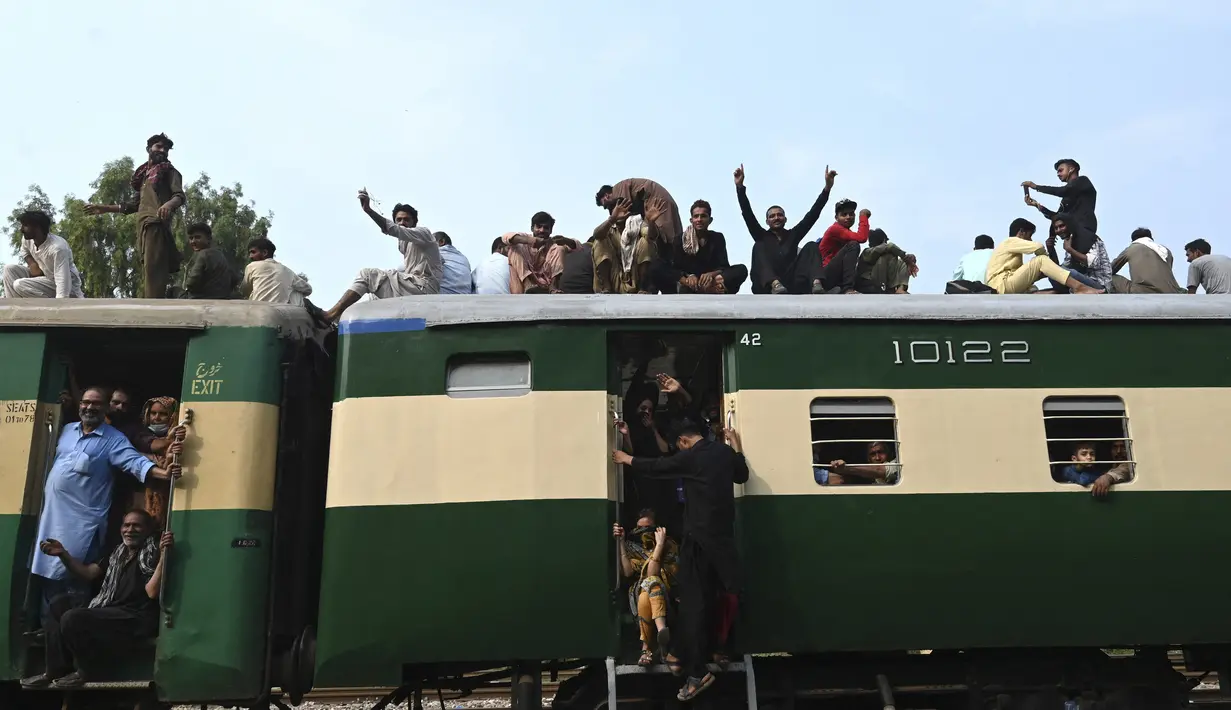 Warga Pakistan menaiki kereta api yang penuh sesak saat orang-orang melakukan perjalanan ke kampung halaman dan desa mereka untuk merayakan Idul Adha, atau "Hari Raya Kurban," di Lahore, Pakistan, Kamis (7/7/2022). Idul Adha, hari raya Islam terpenting, menandai kesediaan Nabi Ibrahim, Ibrahim untuk mengorbankan anaknya. (AFP/Arif Ali)
