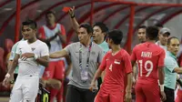 Wasit memberikan kartu merah kepada bek Timnas Indonesia, Putu Gede, saat melawan Singapura pada laga Piala AFF di Stadion Nasional, Singapura, Jumat (9/11). Singapura menang 1-0 atas Indonesia. (Bola.com/M. Iqbal Ichsan)