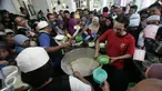 Pengurus masjid membagikan bubur kepada masyarakat di Masjid Darussalam,Solo, Selasa (7/6).Tradisi bubur Ramadan diselenggarakan dengan rata-rata 1100 porsi/hari. (Liputan6.com/Boy Harjanto)