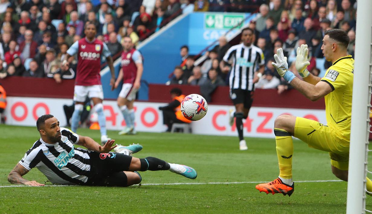 Kiper Aston Villa, Emiliano Martinez berhasil menepis tendangan striker Newcastle United, Callum Wilson yang telah terperangkap offside pada laga lanjutan Liga Inggris 2022/2023 di Villa Park, Birmingham (15/4/2023). (AFP/Geoff Caddick)