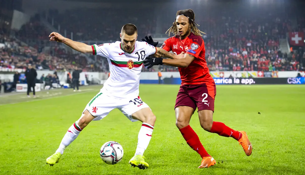Pemain Bulgaria Radoslav Kirilov (kiri) dan pemain Swiss Kevin Mbabu berebut bola pada pertandingan sepak bola kualifikasi Piala Dunia 2022 di Stadion Swissporarena, Lucerne, Swiss, 15 November 2021. Swiss menang 4-0. (Urs Flueeler/Keystone via AP)