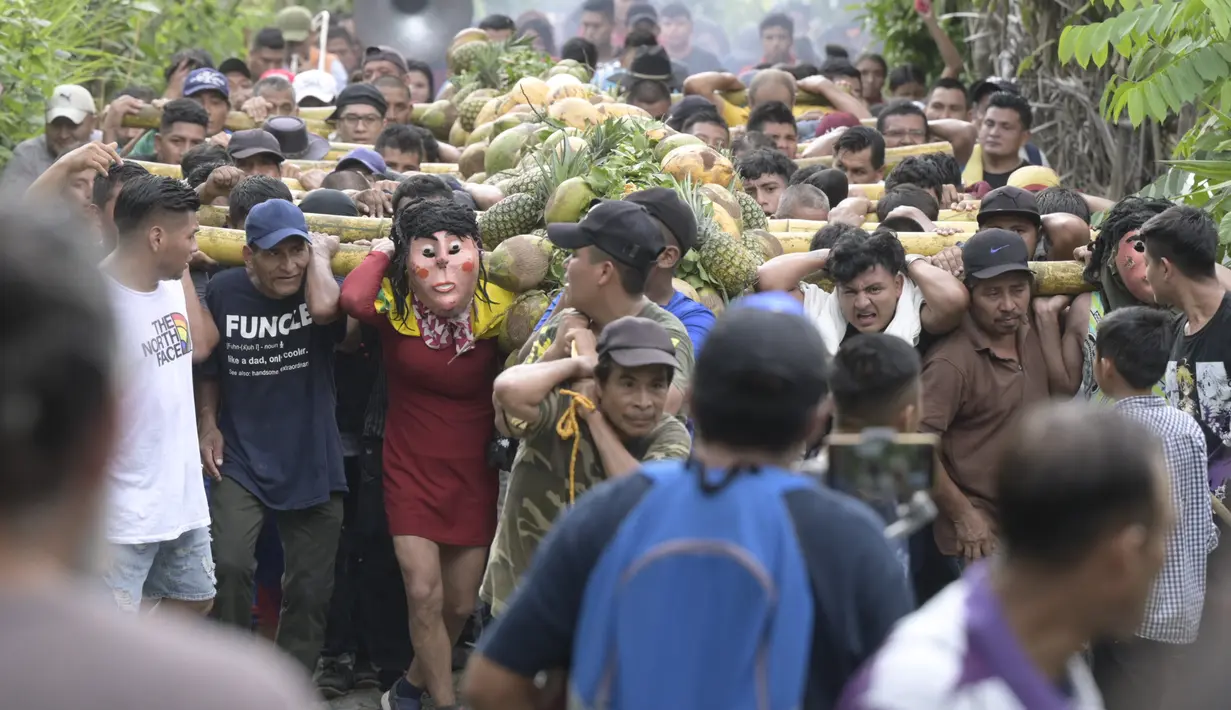 Laki-laki membawa seikat buah di tiang bahu selama perayaan Santa Cruz di Santa Maria Ostuma, 65 km timur San Salvador (31/5/2022). Ratusan orang Salvador membawa buah dengan yodes kayu berjalan melalui desa Santa Maria Ostuma di El Salvador tengah untuk berterima kasih kepada Salib Suci atas panen yang melimpah. (AFP/MARVIN RECINOS)
