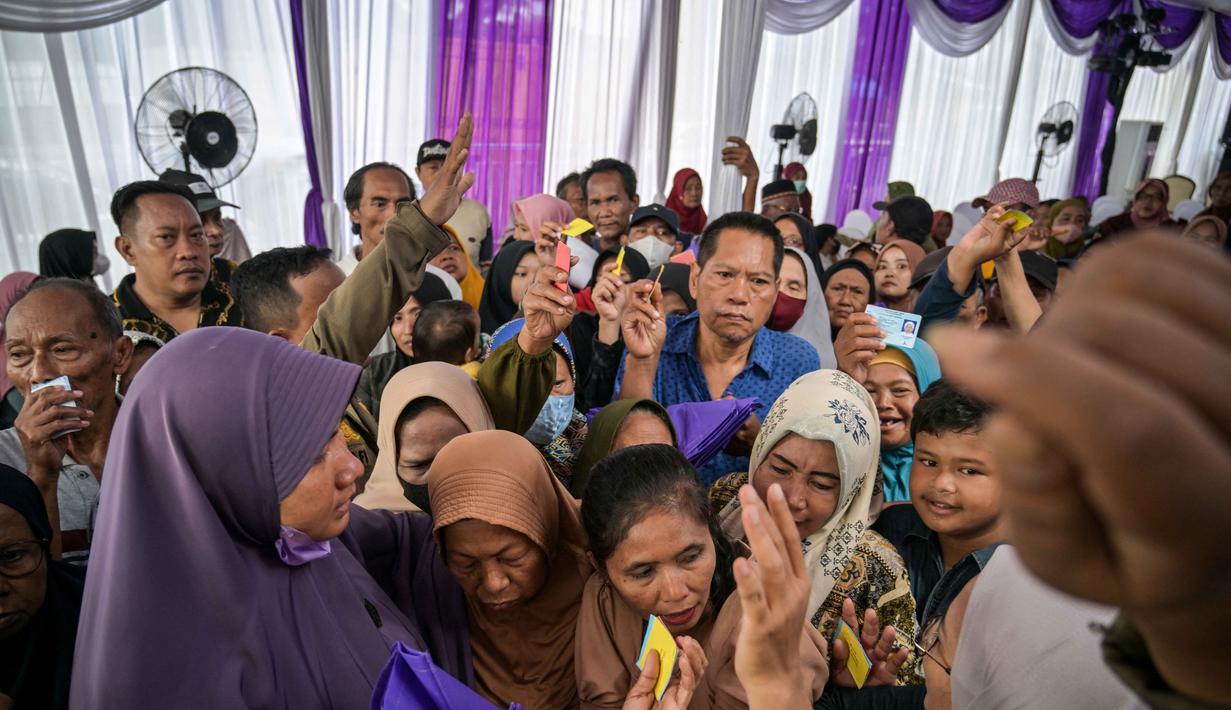 Kegiatan yang berkonsep Garage Day ini bertujuan membantu masyarakat dalam memenuhi kebutuhan atau pangan untuk anak-anak dan keluarga saat merayakan Hari Raya Idul Fitri. Tampak dalam foto, orang-orang mengantre untuk menerima barang-barang gratis seperti pakaian, bahan makanan pokok, dan perlengkapan rumah tangga yang disediakan oleh Asosiasi Organisasi Wanita (GOW) dan pemerintah daerah selama acara aksi sosial tahunan di bulan Ramadan, Surabaya pada Senin 2 Maret 2026. (JUNI KRISWANTO/AFP)