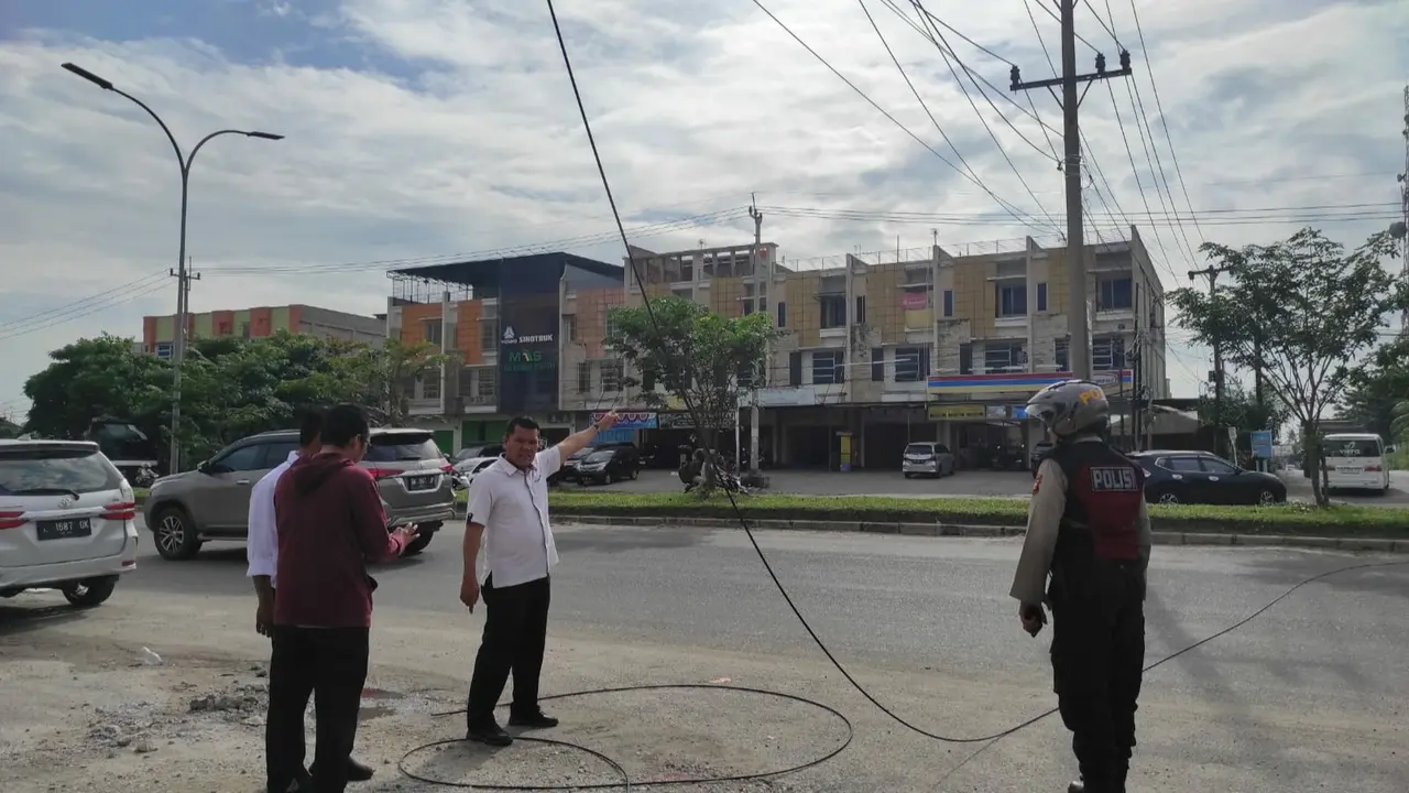 Personel Polresta Pekanbaru mendatangi lokasi kabel menjuntai yang membuat dua pelajar terjatuh dari sepeda motor.