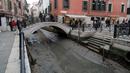 Pemandangan kanal kering saat air surut di Venesia, Italia, 21 Februari 2023. Italia menetapkan keadaan darurat kekeringan pada musim panas lalu. (AP Photo/Luigi Costantini)