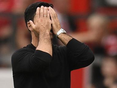 Ekspresi pelatih Arsenal, Mikel Arteta yang menutup wajahnya sebagai reaksi dari kekalahan timnya saat bertandang ke Markas Manchester United dalam pertandingan pekan keenam Liga Inggris 2022/2023. (AFP/Oli Scarff)