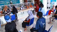 Warga antre menerima Bantuan Sosial Tunai (BST) di Kelurahan Pondok Benda, Kecamatan Pamulang, Tangerang Selatan, Minggu (10/01/2021). BST senilai Rp300 ribu akan disalurkan selama empat bulan berturut-turut mulai dari Januari - April 2021. (Liputan6.com/Fery Pradolo)