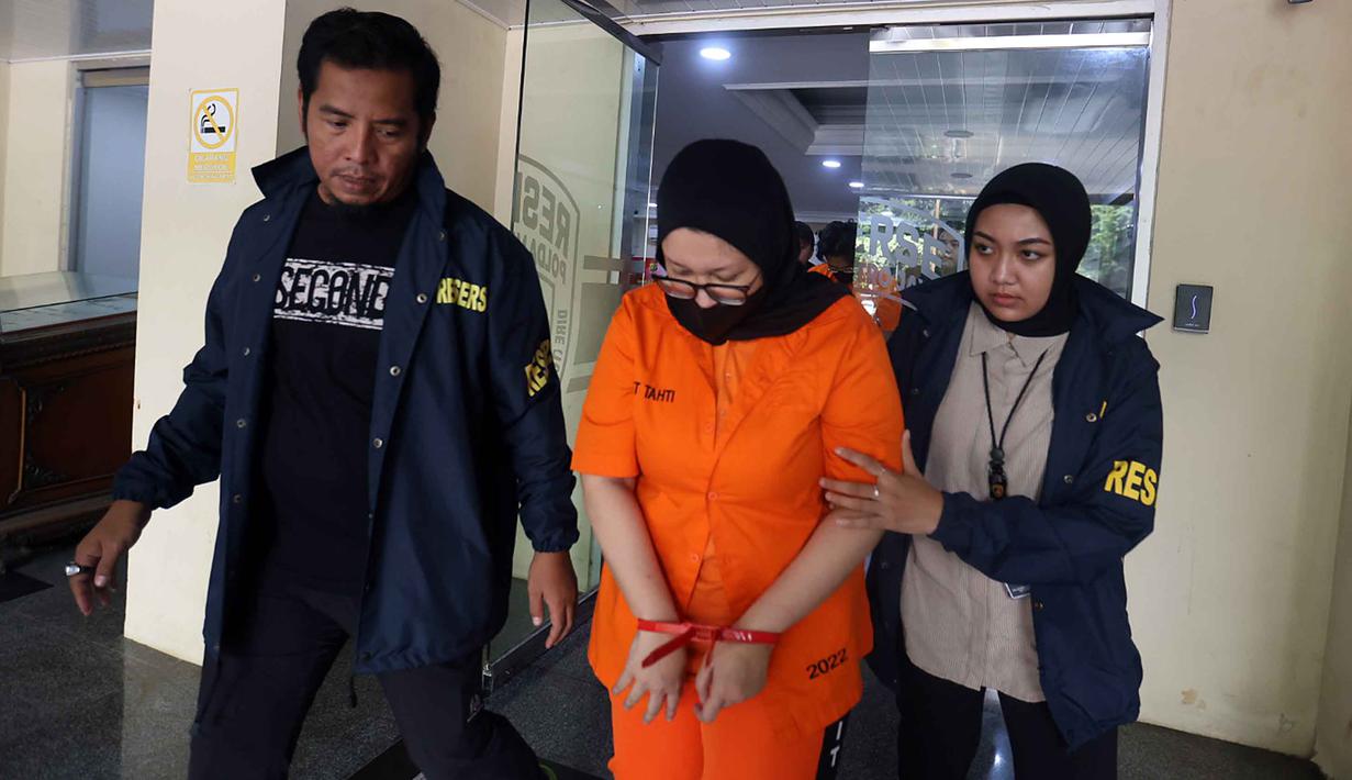 Ayu Puspita, pemilik Wedding Organizer by Ayu Puspita (tengah), digelandang petugas dari unit Kriminal Umum Polda Metro Jaya usai rilis di Gedung Ditreskrimum Polda Metro Jaya, Sabtu (13/12/2025). Polda Metro Jaya merilis kasus penipuan yang dilakukan Ayu Puspita, pemilik Wedding Organizer by Ayu Puspita. (Kapanlagi.com/Budy Santoso)