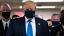 Presiden Amerika Serikat Donald Trump mengenakan masker saat mengunjungi Pusat Kesehatan Militer Nasional Walter Reed di Bethesda, Maryland, Sabtu (11/7/2020). Donald Trump akhirnya menggunakan masker untuk pertama kalinya di depan umum sejak pandemi COVID-19 melanda negara itu.  (ALEX EDELMAN/AFP)