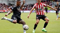 Striker Arsenal, Gabriel Jesus, dikawal oleh bek Brentford, Aaron Hickey, saat kedua tim berhadapan pada laga pekan kedelapan Premier League 2022/2023 di Gtech Community Stadium, London, Minggu (18/9/2022). (Ian Kington / AFP)