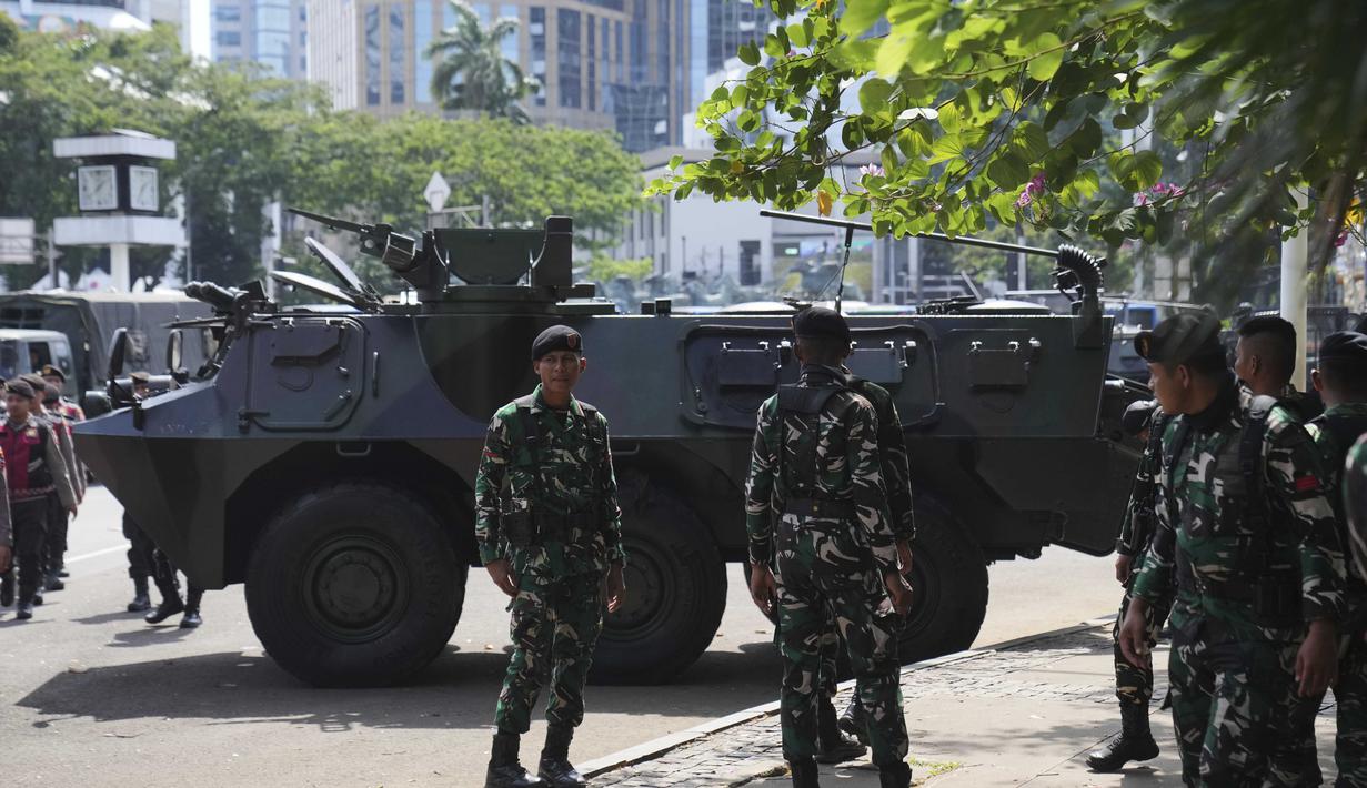 Personel Tentara Nasional Indonesia (TNI) berdiri di dekat kendaraan lapis baja yang diparkir di dekat Monumen Nasional, Jakarta, Selasa 2 September 2025. (AP Photo/Dita Alangkara)