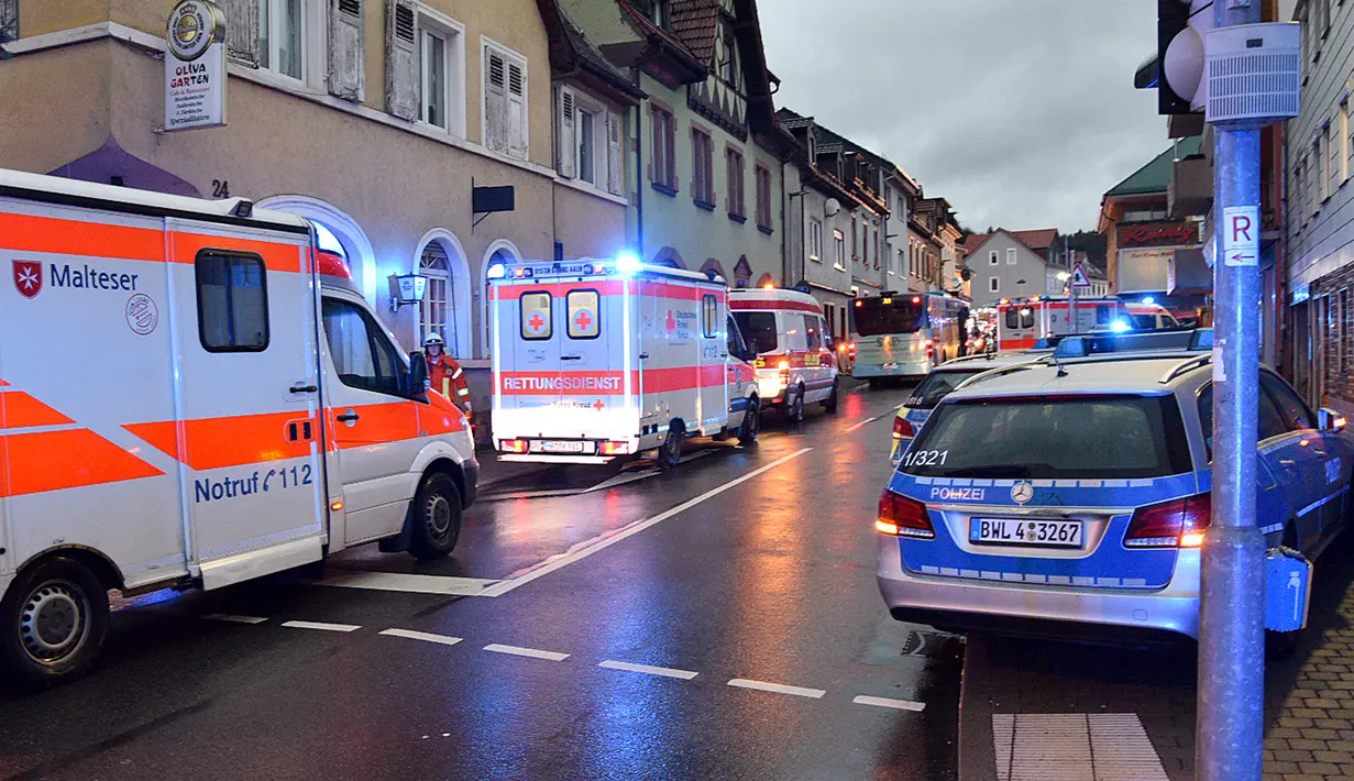 Kendaraan polisi dan ambulans berada di lokasi bus sekolah menabrak tembok sebuah toko di Eberbach dekat Mannheim, Jerman, Selasa (16/1). Tiga helikopter dikerahkan untuk menyelamatkan korban dan membawanya mereka ke rumah sakit. (Rene Priebe/dpa/AFP)