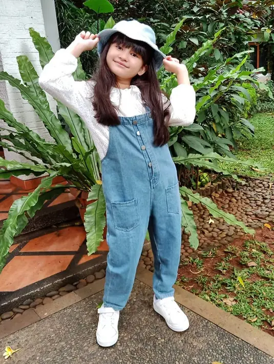 Menggunakan konsep busana serba putih yang dipadukan dengan jumpsuit jeans serta busket hat, gaya gadis 9 tahun ini banjir pujian. Tak sedikit pula yang menyebut jika penampilannya di berbagai kesempatan terlihat sederhana namun tetap stylish. (Liputan6.com/IG/@graciellaabigail)