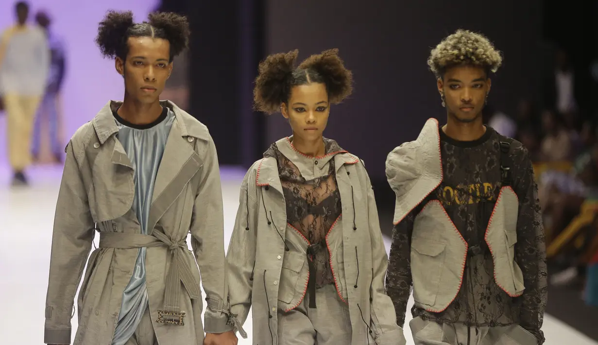 Tiga model berjalan di catwalk mengenakan busana kreasi Maxivive selama Heineken Fashion and Design Week di Lagos, Nigeria (26/10/2019). Lagos Fashion Week (LFWNG) adalah acara mode multi-hari tahunan yang didirikan pada 2011 oleh Omoyemi Akerele. (AP Photo/Sunday Alamba)