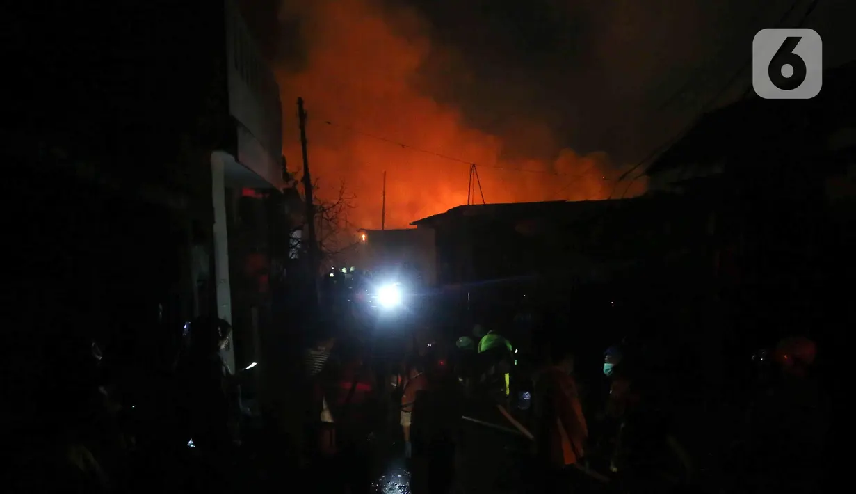 Sejumlah unsur terkait terlihat membantu petugas pemadam memadamkan api yang terjadi di kawasan Depo Pertamina Plumpang, Jakarta Utara, Jumat (3/3/2023) malam. Sedikitnya, pemadam kebakaran mengerahkan 18 unit mobil dengan 90 personel. (Liputan6.com/Herman Zakharia)