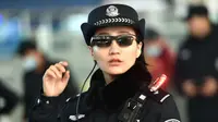 Petugas polisi China mengenakan kacamata smartglasses dengan sistem pengenalan wajah di Stasiun Kereta Zhengzhou East di Zhengzhou di provinsi Henan tengah China (5/2). Kacamata hitam ini bisa mendeteksi buronan atau tersangka. (AFP Photo/China Out)