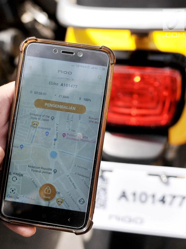 Warga menggunakan aplikasi pada smartphone saat hendak menyalakan Migo e-Bike di kawasan Bundaran HI, Jakarta, Minggu (30/12). Migo diharapkan dapat menjadi solusi kemacetan dan mengurangi pencemaran udara. (Merdeka.com/Iqbal S. Nugroho)