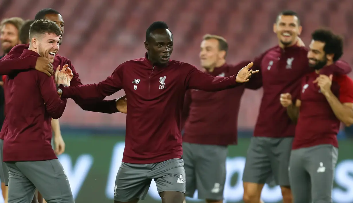 Striker Liverpool, Sadio Mane (tengah) bercanda dengan rekan-rekannya selama sesi latihan di stadion San Paolo di Naples, Italia (2/10). Liverpool akan bertanding melawan Napoli pada grup C Liga Champions. (AFP Photo/Carlo Hermann)