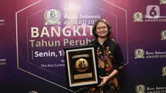 Irnawati W. Kahardja selaku Head of Protocol and Public Affairs PT Surya Citra Media Tbk, berpose dengan piagam usai penganugerahan Bisnis Indonesia Award (BIA) 2022 di Jakarta, Senin (15/8/2022). PT Surya Citra Media TBK mendapatkan penghargaan Bisnis Indonesia Award (BIA) 2022 dalam kategori Media dan Hiburan. (Liputan6.com/Herman Zakharia)